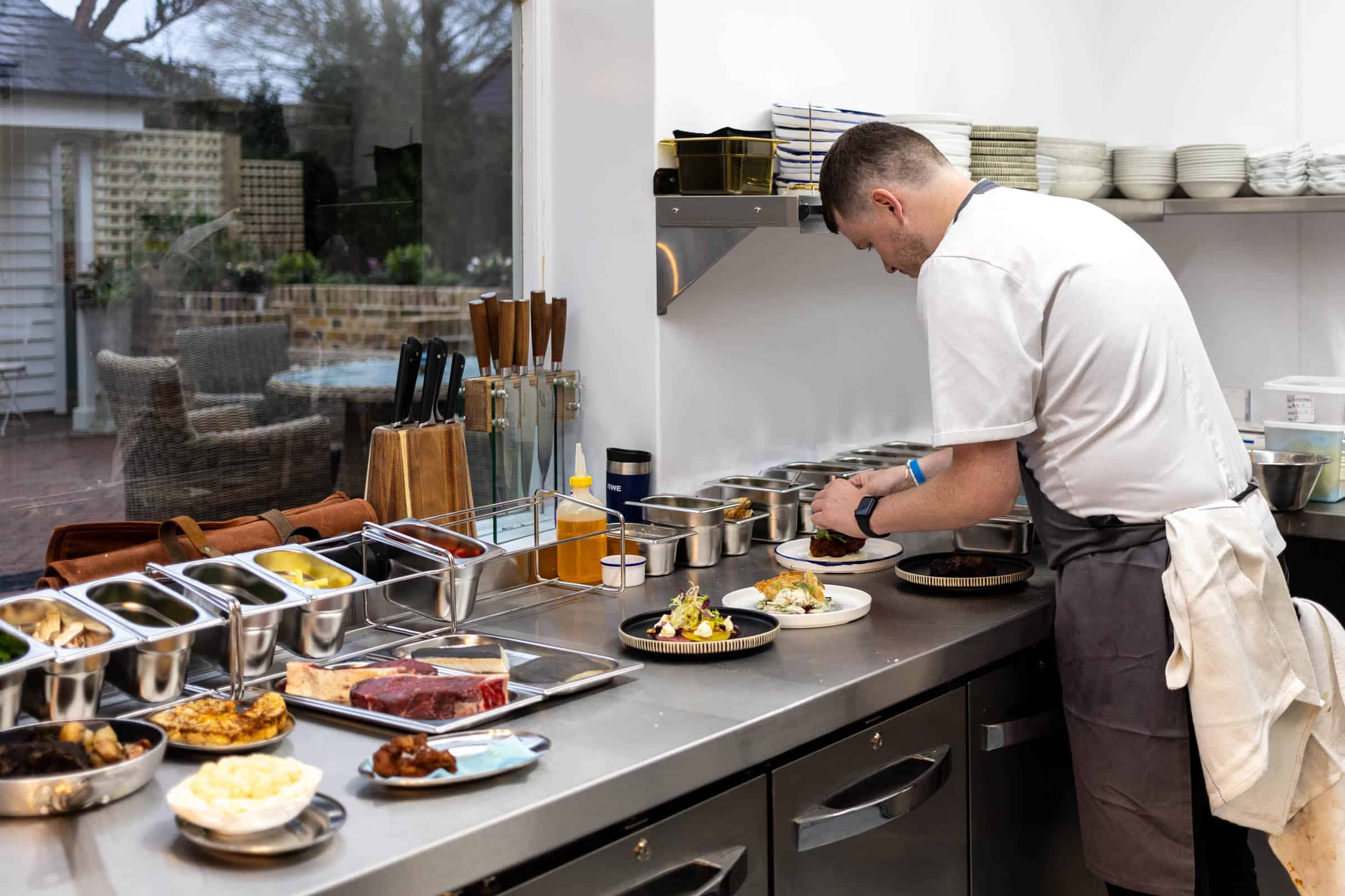 Chef plating at the pass in the Blue Pigeons kitchen