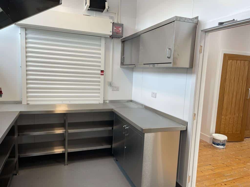 Stainless steel prep counter and fire-rated roller shutter at Frittenden Memorial Hall