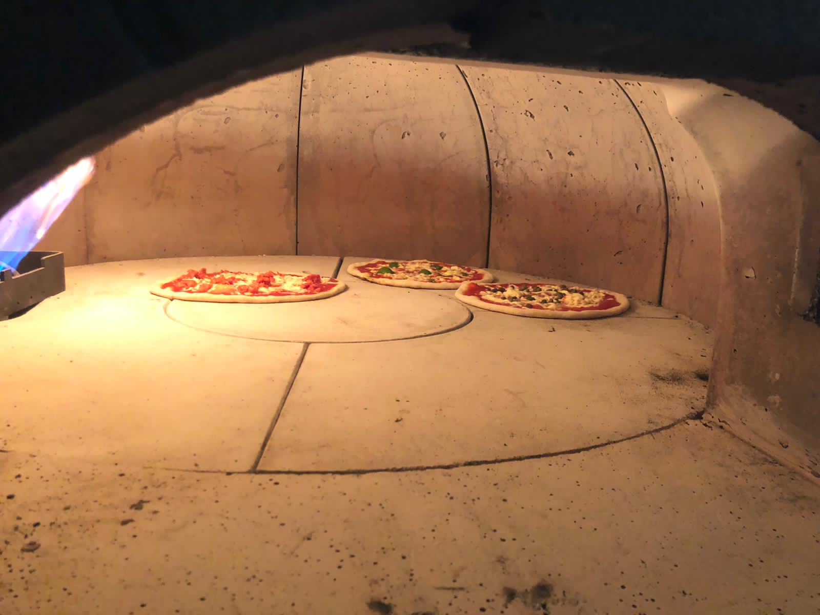 Wood-fired oven with pizzas at Unita Quattro, Ashford