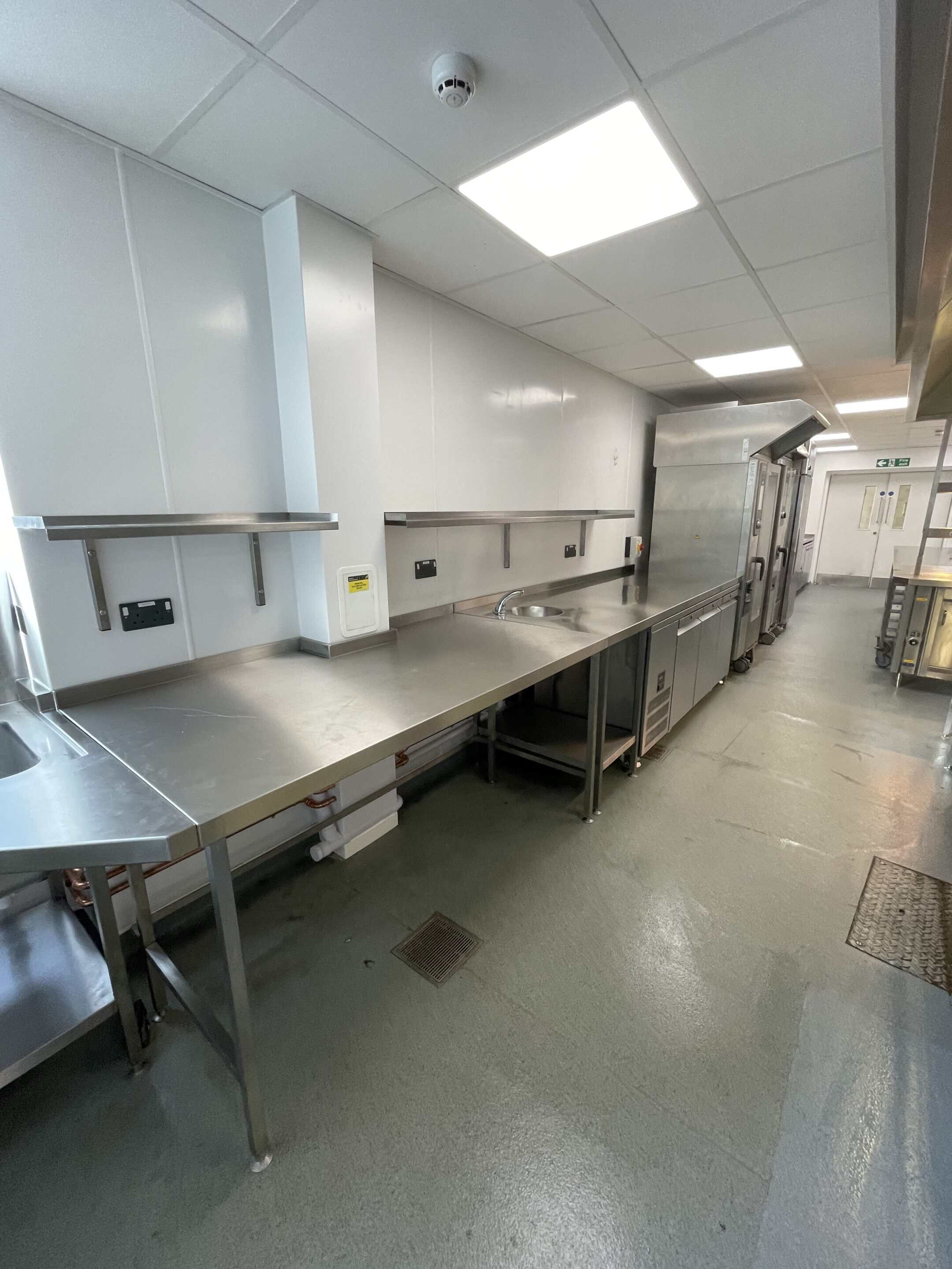 Stainless steel prep run and wall shelving at The Yarrow Hotel kitchen